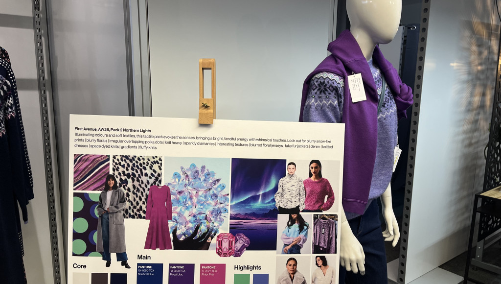 Display featuring a mannequin dressed in winter apparel alongside a board highlighting fashion collection themes. The board includes color palettes, fabrics, and images showcasing the collection inspired by Northern Lights, with sections labeled 'Core,' 'Main,' and 'Highlights.'